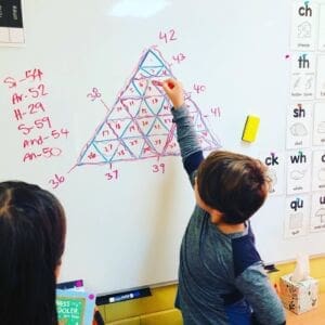 Boy doing math on dry erase board