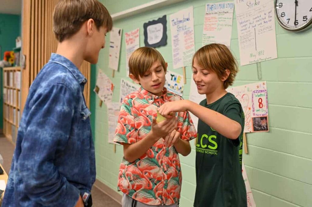 Middle school boys discuss project at micro school.