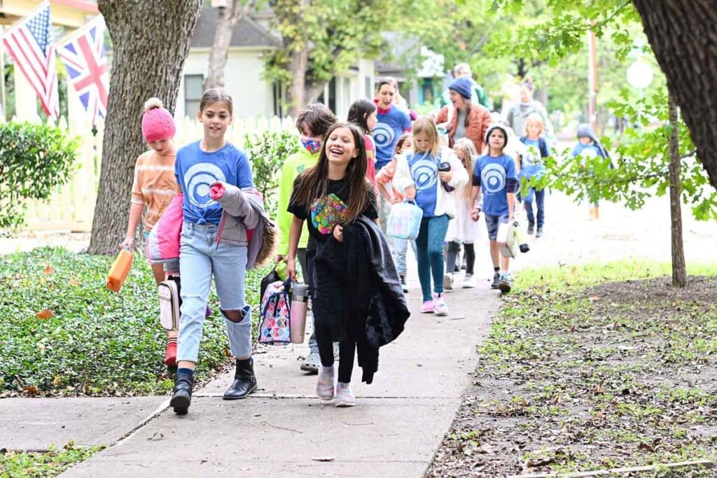 Micro school elementary students walk together to park.